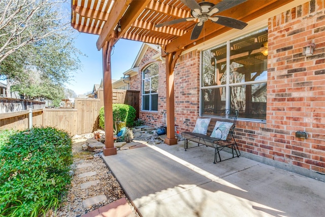 view of patio with ceiling fan and fence