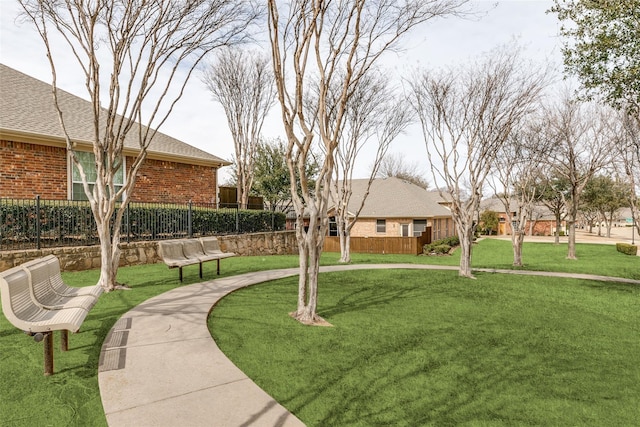 view of home's community featuring a yard and fence