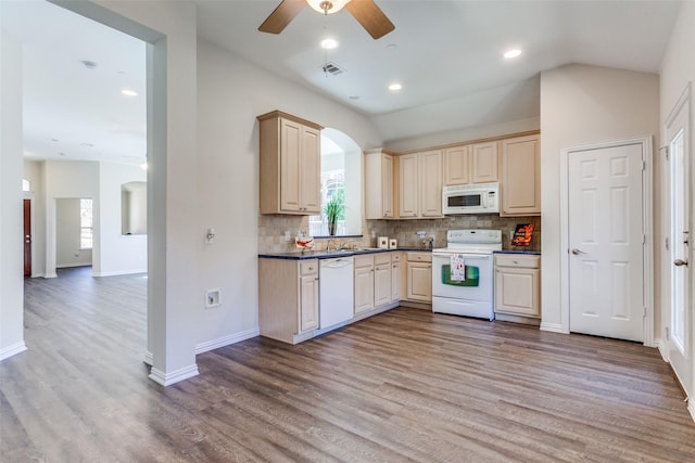 kitchen featuring white appliances, visible vents, light wood-style flooring, dark countertops, and backsplash