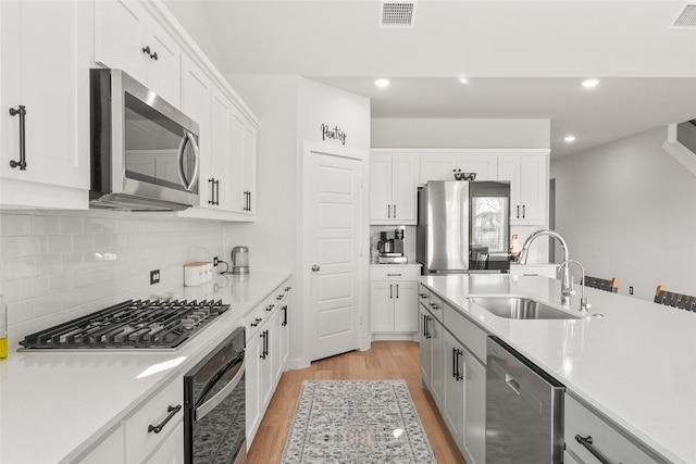 kitchen with visible vents, stainless steel appliances, a sink, and light countertops