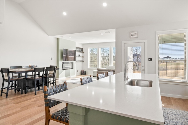 kitchen with light wood-type flooring, light countertops, and a sink