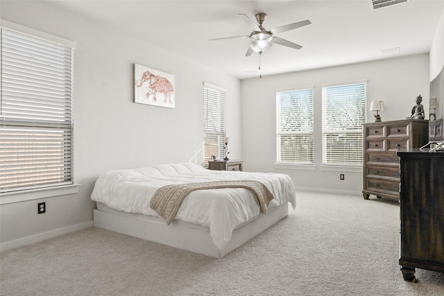 carpeted bedroom with baseboards, visible vents, and a ceiling fan