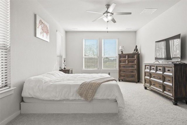 carpeted bedroom with visible vents, ceiling fan, and baseboards