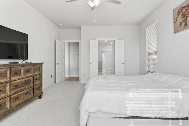 bedroom featuring light carpet, ceiling fan, baseboards, and connected bathroom