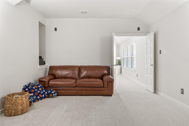 living room featuring carpet floors, lofted ceiling, visible vents, and baseboards