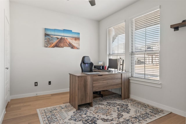 office space featuring light wood-style floors, ceiling fan, and baseboards