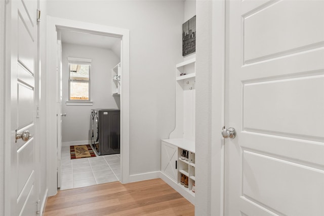 mudroom with light wood-style flooring, baseboards, and independent washer and dryer