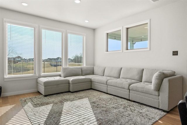 living room with baseboards, wood finished floors, and recessed lighting