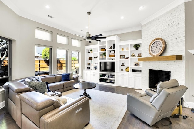 living room featuring a large fireplace, ceiling fan, ornamental molding, wood finished floors, and recessed lighting