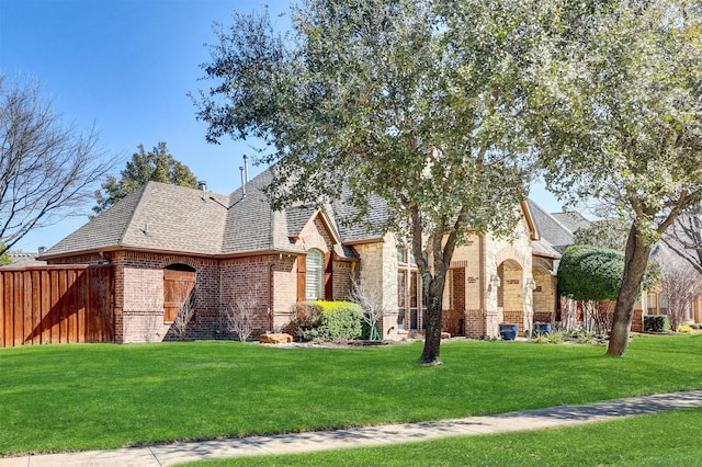 view of front of house with stone siding, brick siding, and a front yard