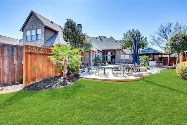 back of property featuring a yard, fence, a patio, and a gazebo