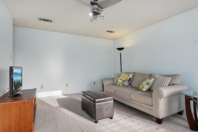 carpeted living area with visible vents, baseboards, and ceiling fan