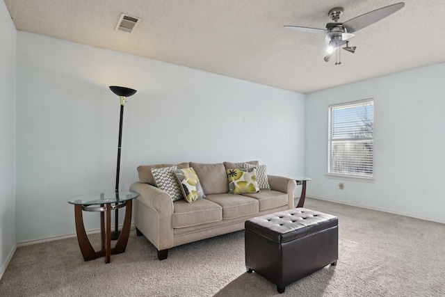 living area with visible vents, a textured ceiling, carpet, and a ceiling fan