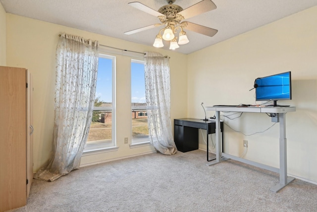 carpeted home office with a ceiling fan, baseboards, and a textured ceiling