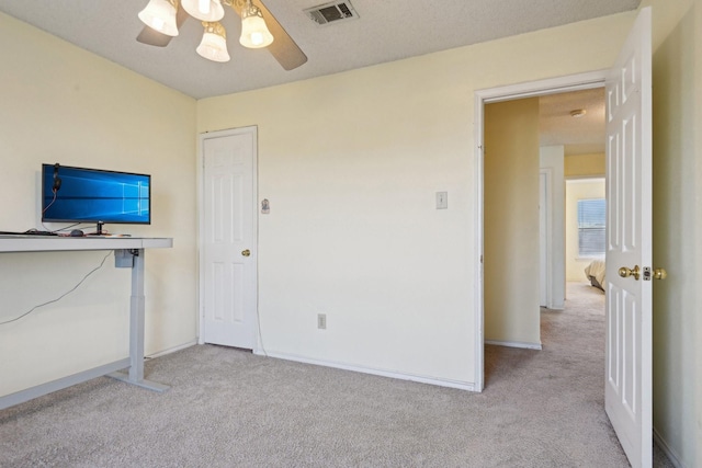 unfurnished bedroom with visible vents, baseboards, a ceiling fan, and carpet flooring