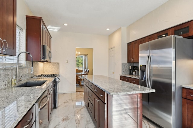 kitchen featuring backsplash, a center island, appliances with stainless steel finishes, marble finish floor, and a sink