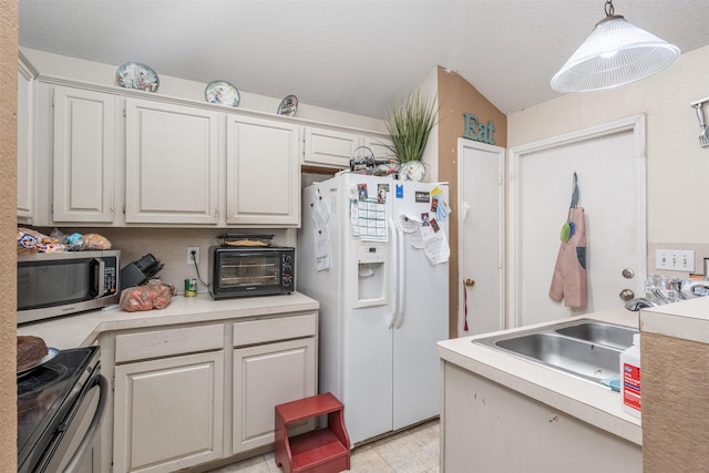 kitchen featuring range with electric cooktop, a sink, stainless steel microwave, white refrigerator with ice dispenser, and light countertops