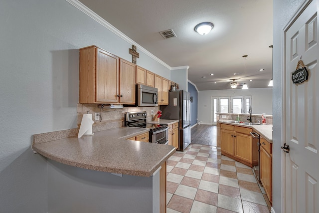 kitchen featuring crown molding, backsplash, appliances with stainless steel finishes, a sink, and a peninsula