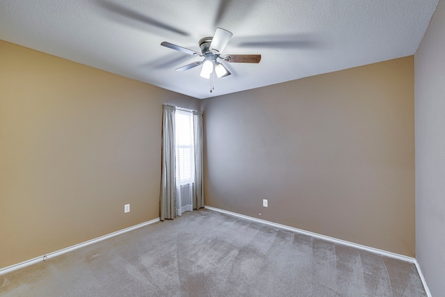 carpeted spare room with ceiling fan, a textured ceiling, and baseboards