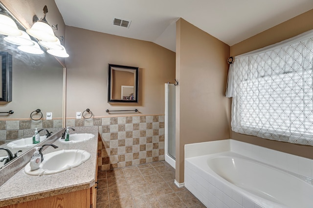 full bath with visible vents, a sink, and a garden tub