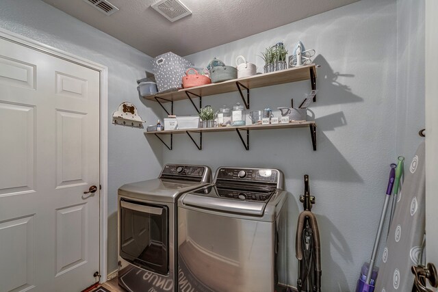 clothes washing area featuring laundry area, a textured ceiling, visible vents, and washer and dryer