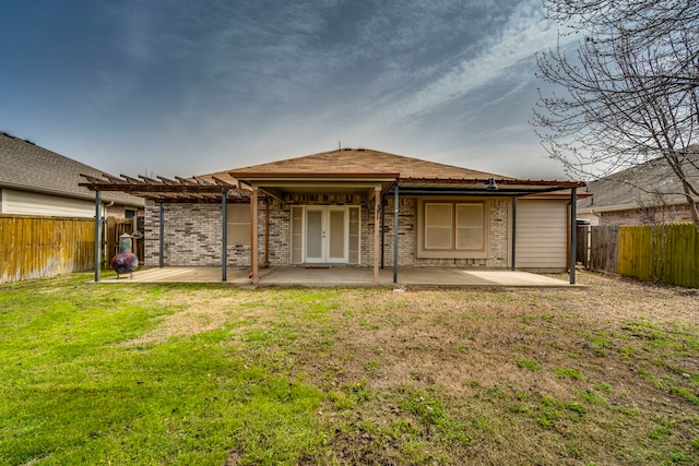 back of house featuring a yard, a patio area, a fenced backyard, and a pergola