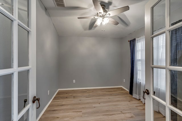 spare room featuring french doors, visible vents, light wood-style flooring, ceiling fan, and baseboards