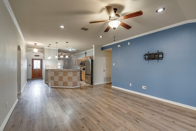 kitchen with arched walkways, visible vents, open floor plan, appliances with stainless steel finishes, and light wood finished floors