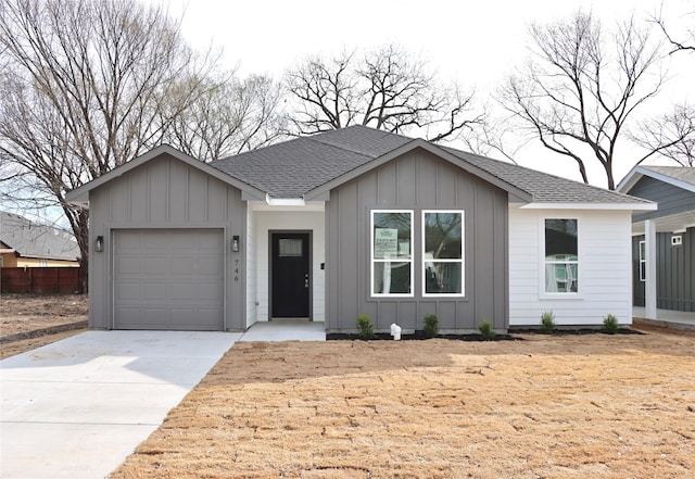 ranch-style home featuring an attached garage, driveway, board and batten siding, and roof with shingles