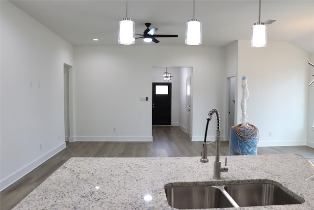 kitchen with decorative light fixtures, a sink, visible vents, and wood finished floors