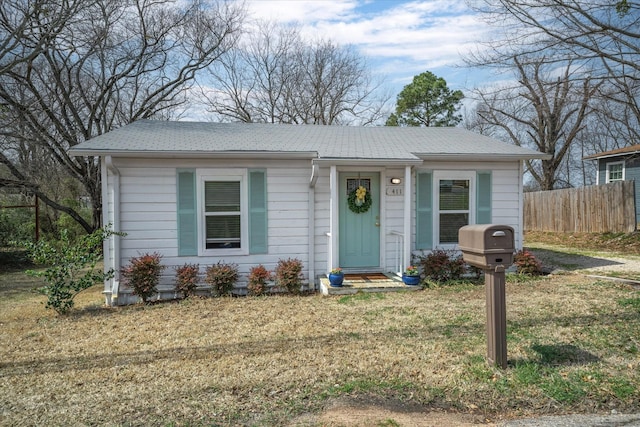 bungalow-style house featuring a front yard and fence