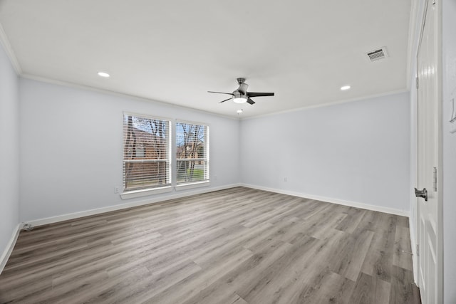 unfurnished room featuring baseboards, visible vents, wood finished floors, and ornamental molding