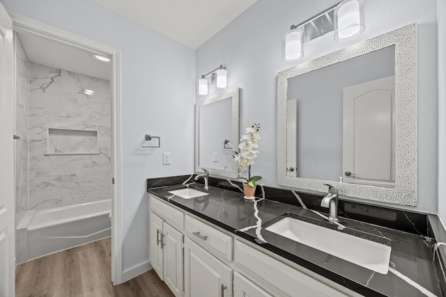 bathroom with double vanity, a sink, shower / tub combination, and wood finished floors