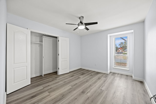 unfurnished bedroom featuring ceiling fan, a closet, light wood-type flooring, and baseboards