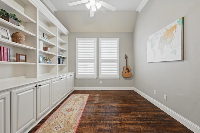 interior space with dark wood finished floors, a ceiling fan, and baseboards