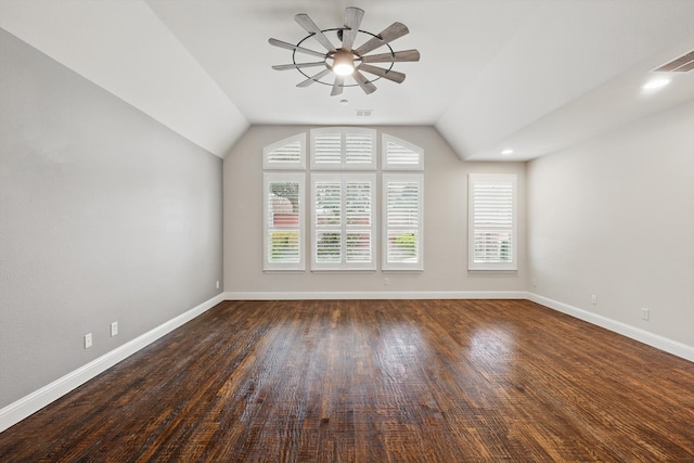 spare room featuring vaulted ceiling, wood finished floors, baseboards, and ceiling fan