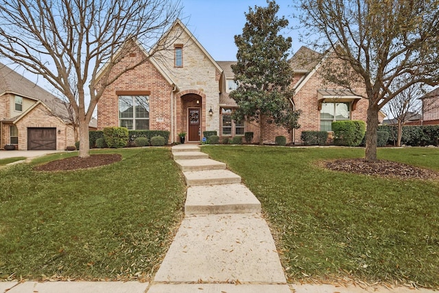 tudor home featuring a front yard and brick siding