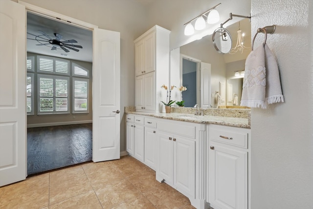 full bathroom featuring tile patterned flooring, ceiling fan with notable chandelier, vanity, and baseboards