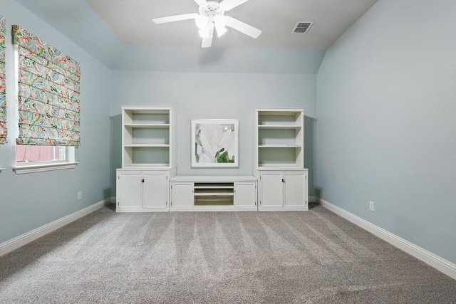 interior space with visible vents, ceiling fan, baseboards, lofted ceiling, and carpet floors