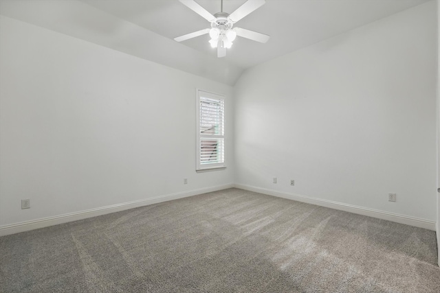 carpeted empty room with baseboards, a ceiling fan, and vaulted ceiling