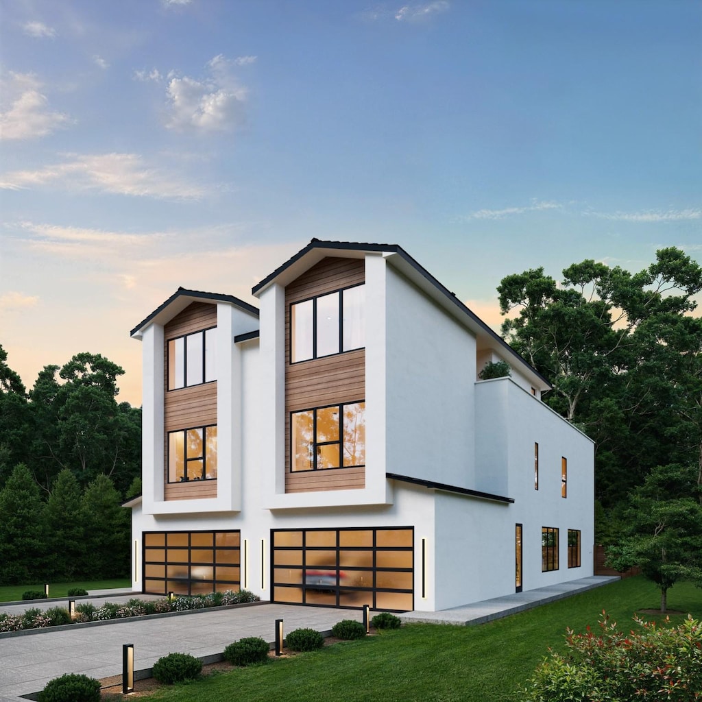 view of front of house with a yard, driveway, an attached garage, and stucco siding