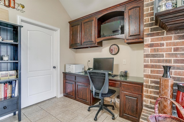 office space with vaulted ceiling and light tile patterned floors