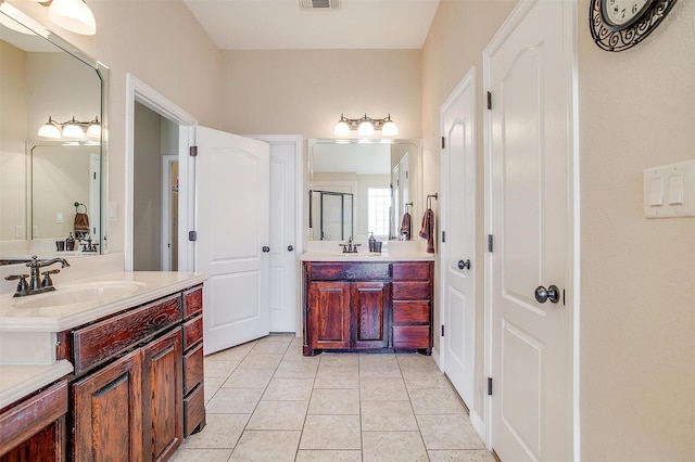 bathroom with tile patterned flooring, visible vents, two vanities, and a sink