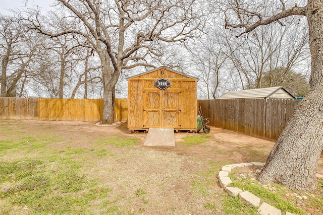 view of yard with an outbuilding, a storage unit, and a fenced backyard