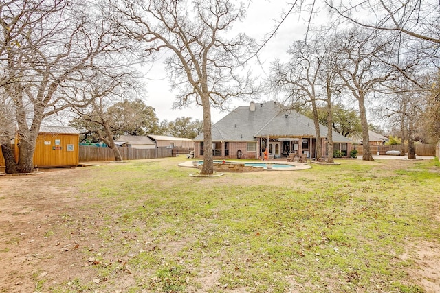 view of yard with a pool, a storage shed, a patio area, a fenced backyard, and an outdoor structure