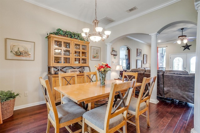 dining space featuring dark wood-style floors, arched walkways, crown molding, decorative columns, and a ceiling fan