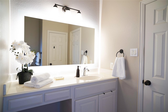 bathroom featuring a textured ceiling and vanity