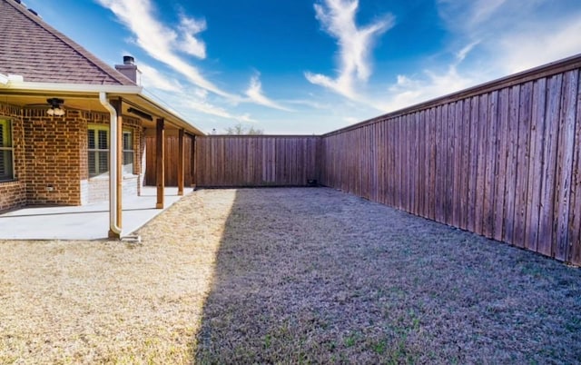 view of yard with a patio, a fenced backyard, and a ceiling fan