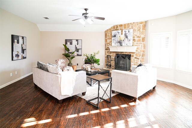 living room with visible vents, a stone fireplace, wood finished floors, and vaulted ceiling