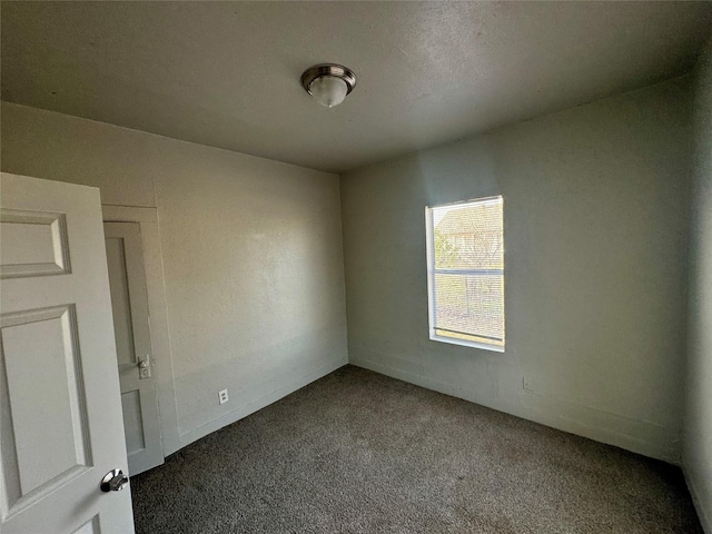 carpeted empty room with baseboards